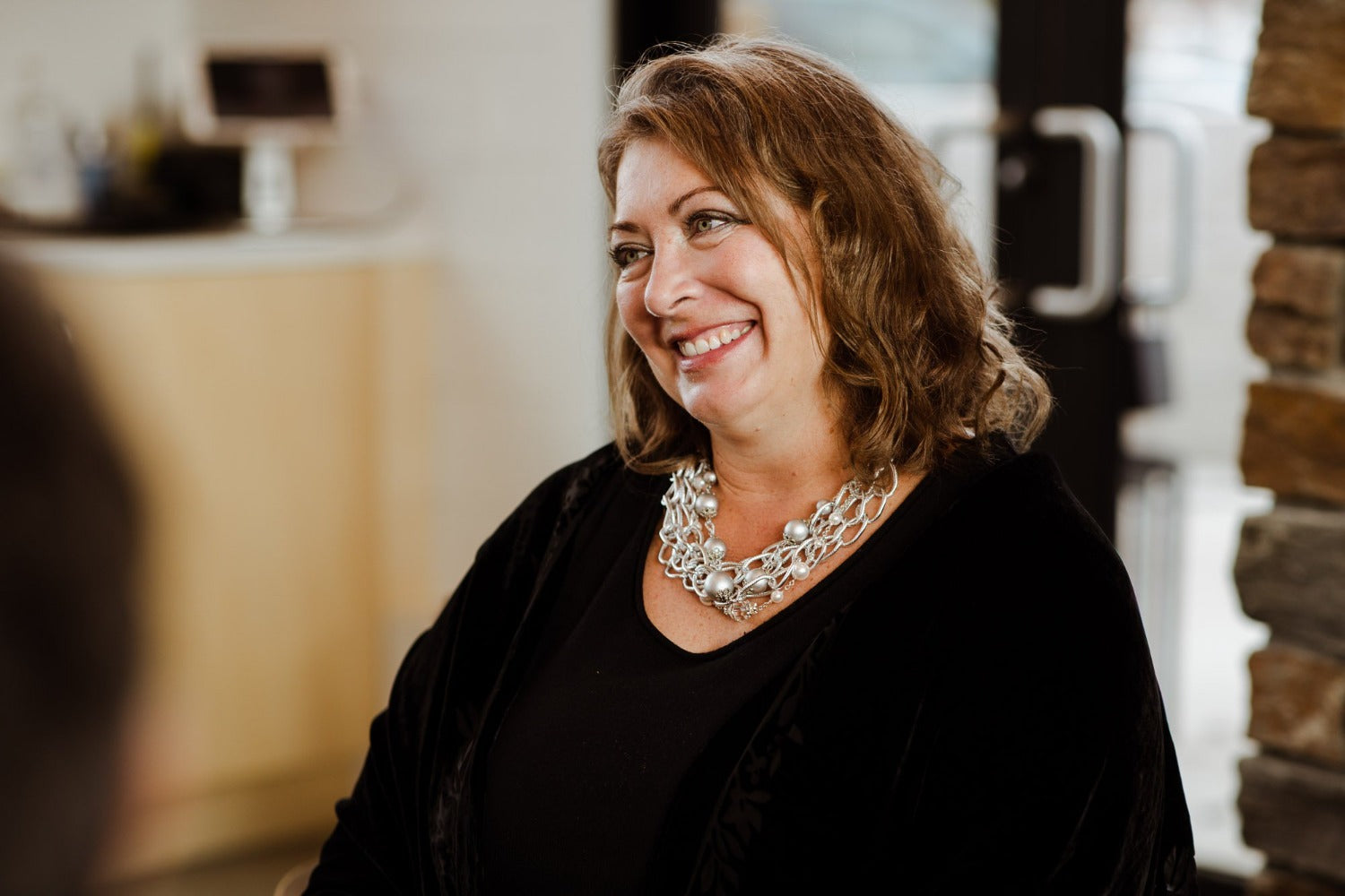 Woman wearing  a silver, crystal and European crystal pearl statement necklace