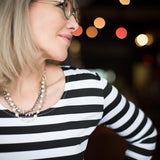 Woman wearing a silver and European crystal and crystal pearl necklace