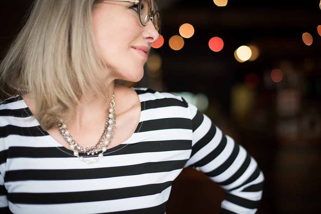 Woman wearing a silver and European crystal and crystal pearl necklace