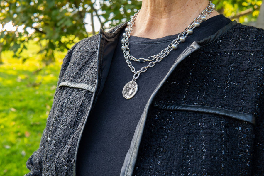 Pearl, silver chain and medallion necklace on woman