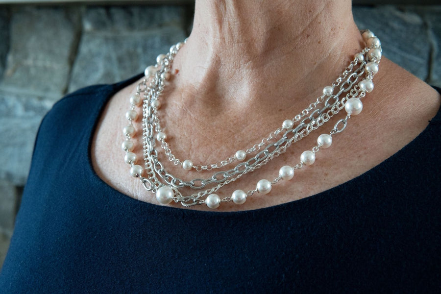 Multi  layer white pearl and silver necklace on woman's neck