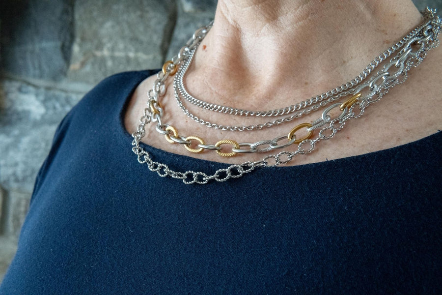 Silver and gold chain necklace on woman's neck