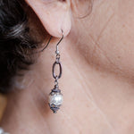 Ornate white pearl earrings on woman