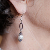 Ornate white pearl earrings on woman