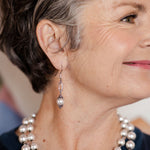 Ornate white pearl earrings on woman