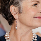 Ornate white pearl earrings on woman