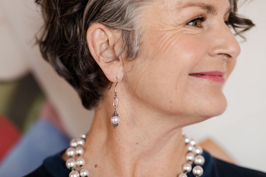 Ornate white pearl earrings on woman