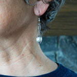 Ornate white pearl earrings on woman