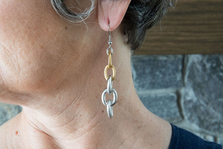 Silver and gold chain earrings on woman