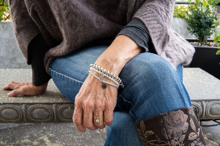 Pearl friendship bracelets on woman's wrists