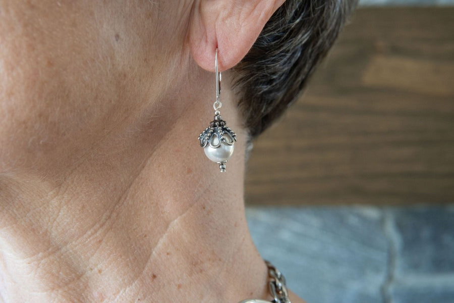 Woman in her fifties wearing European crystal pearl and sterling silver earrings