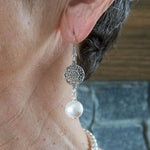 Antique silver and white pearl earrings on woman's ear
