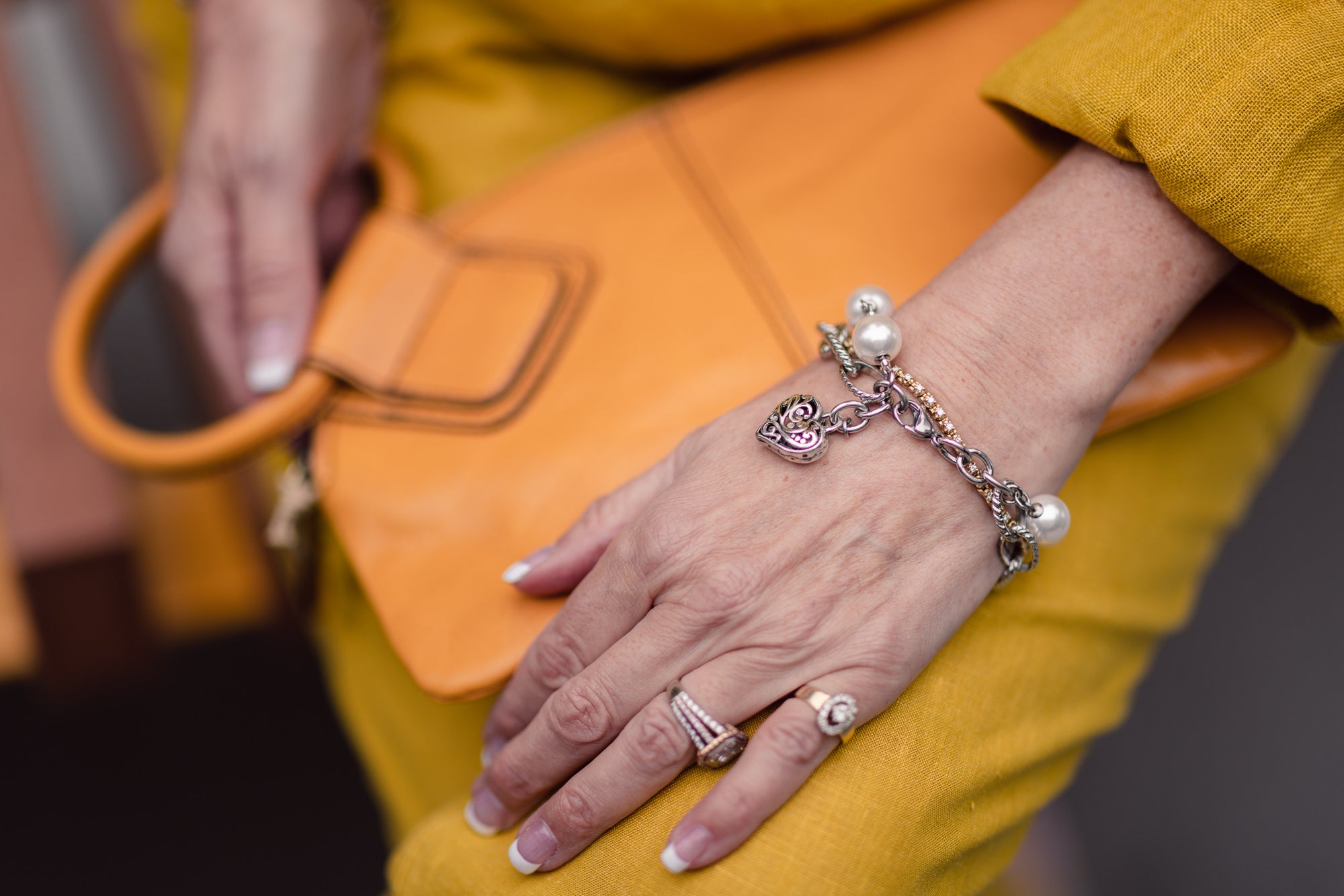 Woman wearing a pewter heart, stainless steel and European crystal pearl bracelet