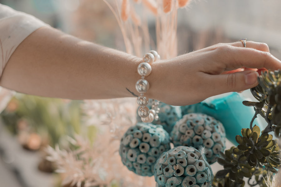 A woman's wrist wearing a white pearl bracelet