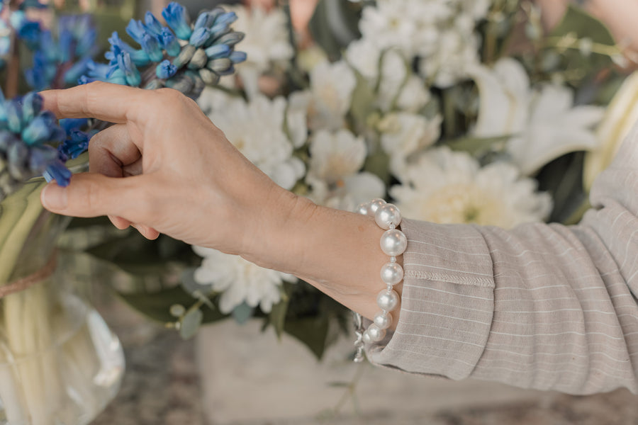 A woman's wrist wearing a white pearl bracelet