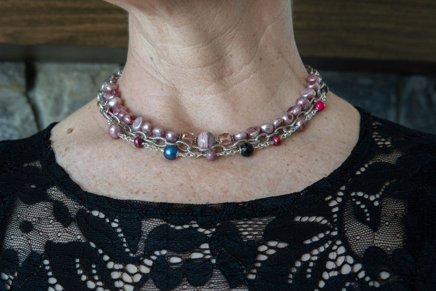 Woman in her fifties wearing a gemstone, pearl and silver statement necklace