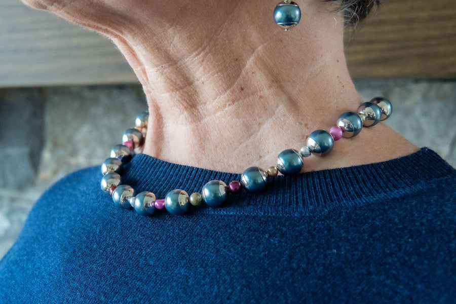 Pearl and gemstone necklace on woman's neck