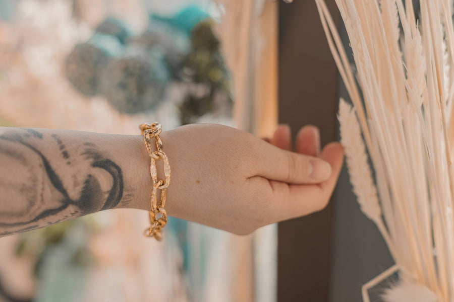 Woman's wrist wearing a gold link bracelet