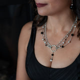 A woman in a black top wearing a Carolily Finery statement necklace made from sterling silver, onyx and European crystal pearls
