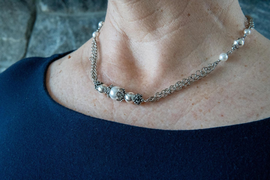 Antique silver and pearl necklace on woman's neck