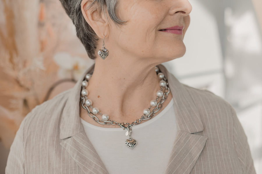 Woman wearing ornate pewter heart earrings
