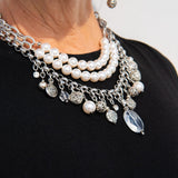 Silver, stainless steel and pearl charm necklace on woman's neck
