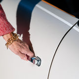 A woman's wrist with a Carolily Finery bracelet made from various gold plated chains