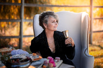 a woman in a black velvet blazer wearing a Carolily Statement necklace made of gold plated chain, various gemstones and freshwater pearls