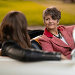 A woman in a car wearing a Carolily Finery statement necklace made from onyx, Swaorvski crystal, gold plated chains and pearls