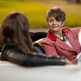 A woman in a car wearing a Carolily Finery statement necklace made from onyx, Swaorvski crystal, gold plated chains and pearls