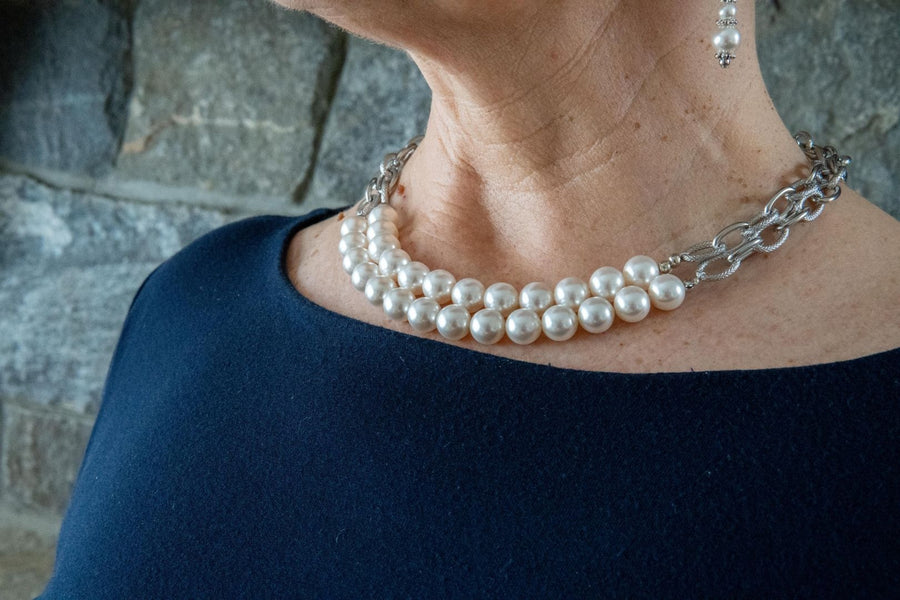 White pearl and silver chain necklace on woman's neck